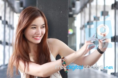 Portrait Of Thai Adult Beautiful Girl Using Her Smart Phone Selfie Stock Photo