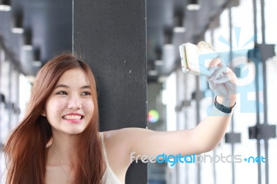 Portrait Of Thai Adult Beautiful Girl Using Her Smart Phone Selfie Stock Photo