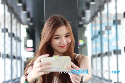 Portrait Of Thai Adult Beautiful Girl Using Her Smart Phone Selfie Stock Photo