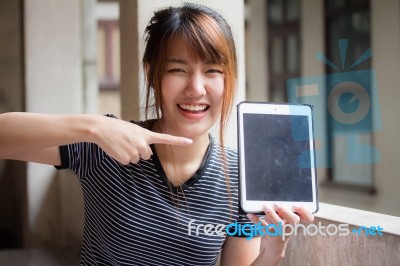 Portrait Of Thai Adult Beautiful Girl Using Her Tablet Stock Photo