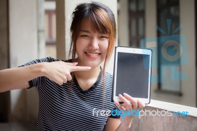 Portrait Of Thai Adult Beautiful Girl Using Her Tablet Stock Photo