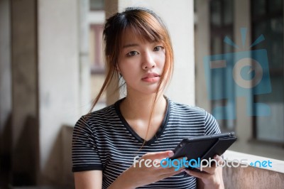 Portrait Of Thai Adult Beautiful Girl Using Her Tablet Stock Photo