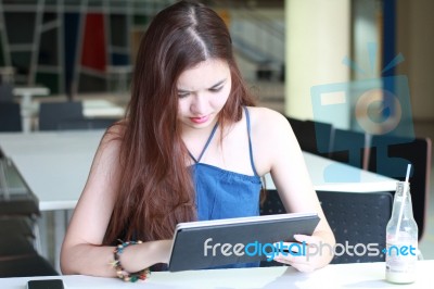 Portrait Of Thai Adult Beautiful Girl Using Her Tablet And Smile In University Stock Photo