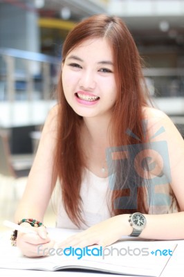 Portrait Of Thai Adult Beautiful Girl Write A Book And Smile In University Stock Photo