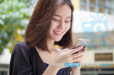 Portrait Of Thai Adult Student University Beautiful Girl Using Her Smart Phone Stock Photo