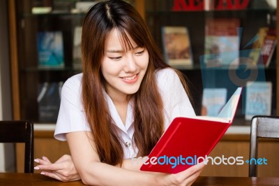 Portrait Of Thai Adult Student University Uniform Beautiful Girl Reading Red Book Stock Photo