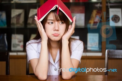 Portrait Of Thai Adult Student University Uniform Beautiful Girl Reading Red Book Stock Photo