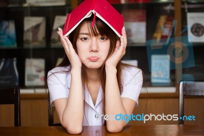 Portrait Of Thai Adult Student University Uniform Beautiful Girl Reading Red Book Stock Photo