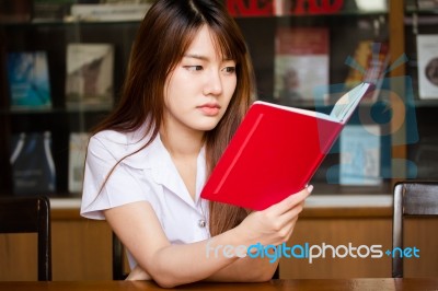 Portrait Of Thai Adult Student University Uniform Beautiful Girl Reading Red Book Stock Photo