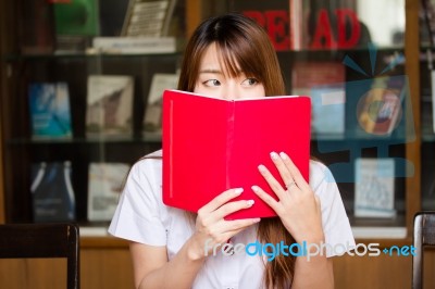 Portrait Of Thai Adult Student University Uniform Beautiful Girl Reading Red Book Stock Photo