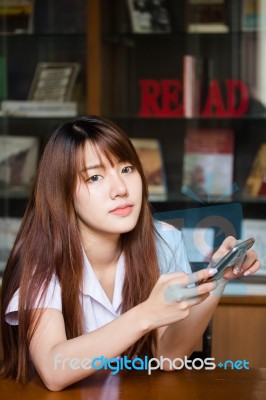 Portrait Of Thai Adult Student University Uniform Beautiful Girl Using Her Smart Phone Stock Photo