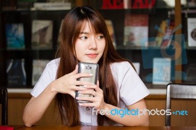 Portrait Of Thai Adult Student University Uniform Beautiful Girl Using Her Smart Phone Stock Photo