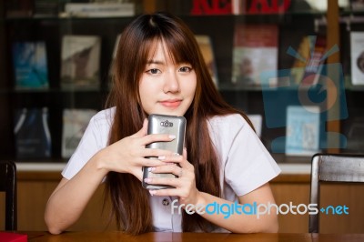 Portrait Of Thai Adult Student University Uniform Beautiful Girl Using Her Smart Phone Stock Photo