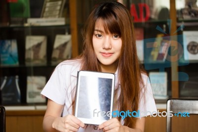 Portrait Of Thai Adult Student University Uniform Beautiful Girl Using Her Tablet Stock Photo