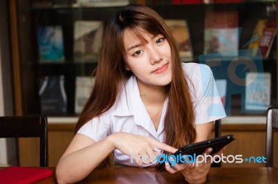 Portrait Of Thai Adult Student University Uniform Beautiful Girl Using Her Tablet Stock Photo