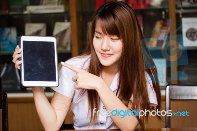 Portrait Of Thai Adult Student University Uniform Beautiful Girl Using Her Tablet Stock Photo