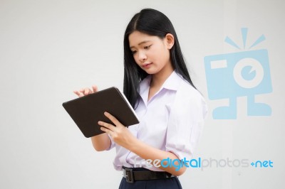 Portrait Of Thai High School Student Uniform Beautiful Girl Using Her Tablet Stock Photo