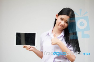 Portrait Of Thai High School Student Uniform Beautiful Girl Using Her Tablet Stock Photo