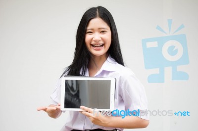 Portrait Of Thai High School Student Uniform Beautiful Girl Using Her Tablet Stock Photo