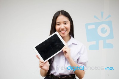 Portrait Of Thai High School Student Uniform Beautiful Girl Using Her Tablet Stock Photo