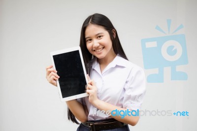 Portrait Of Thai High School Student Uniform Beautiful Girl Using Her Tablet Stock Photo