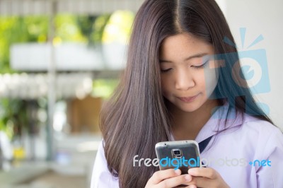 Portrait Of Thai Student Teen Beautiful Girl Using Her Phone And Smile Stock Photo