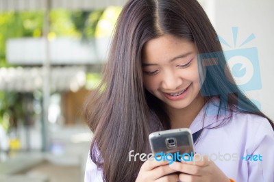 Portrait Of Thai Student Teen Beautiful Girl Using Her Phone And Smile Stock Photo