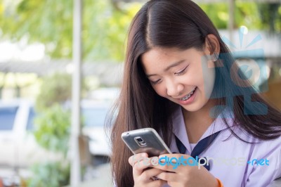 Portrait Of Thai Student Teen Beautiful Girl Using Her Phone And Smile Stock Photo