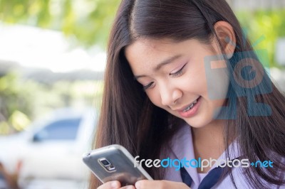 Portrait Of Thai Student Teen Beautiful Girl Using Her Phone And Smile Stock Photo