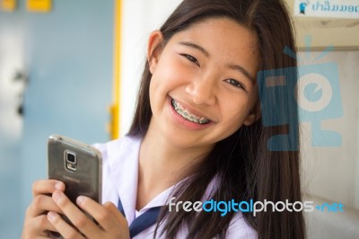 Portrait Of Thai Student Teen Beautiful Girl Using Her Phone And Smile Stock Photo