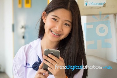 Portrait Of Thai Student Teen Beautiful Girl Using Her Phone And Smile Stock Photo