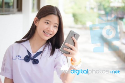 Portrait Of Thai Student Teen Beautiful Girl Using Her Phone And Smile Stock Photo