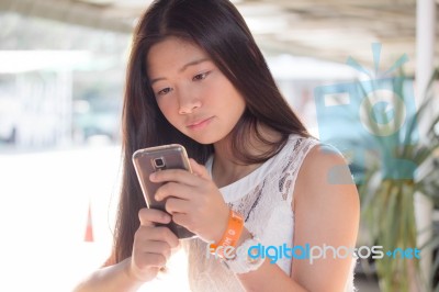 Portrait Of Thai Student Teen Beautiful Girl Using Her Phone And Smile Stock Photo