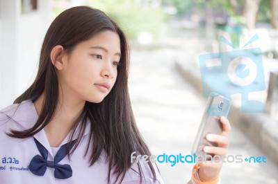 Portrait Of Thai Student Teen Beautiful Girl Using Her Phone And Smile Stock Photo