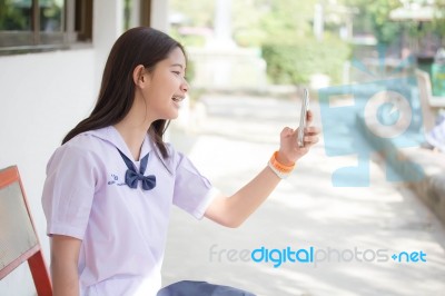 Portrait Of Thai Student Teen Beautiful Girl Using Her Smart Phone Selfie In School Stock Photo