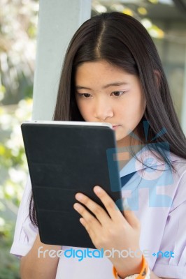 Portrait Of Thai Student Teen Beautiful Girl Using Her Tablet Stock Photo