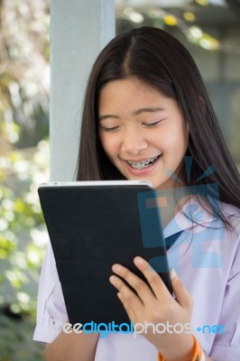 Portrait Of Thai Student Teen Beautiful Girl Using Her Tablet Stock Photo