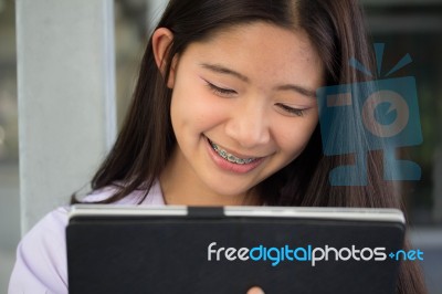 Portrait Of Thai Student Teen Beautiful Girl Using Her Tablet Stock Photo