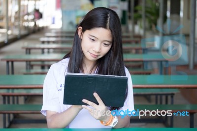 Portrait Of Thai Student Teen Beautiful Girl Using Her Tablet Stock Photo