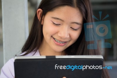 Portrait Of Thai Student Teen Beautiful Girl Using Her Tablet Stock Photo