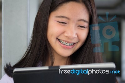 Portrait Of Thai Student Teen Beautiful Girl Using Her Tablet Stock Photo