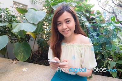 Portrait Of Thai Student University Beautiful Girl Using Her Smart Phone Stock Photo