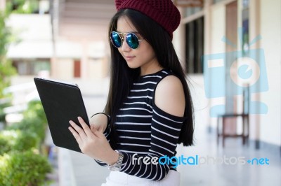 Portrait Of Thai Teen Beautiful Girl Using Her Tablet Stock Photo