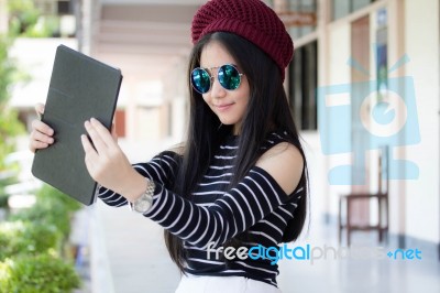 Portrait Of Thai Teen Beautiful Girl Using Her Tablet Stock Photo