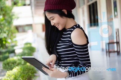 Portrait Of Thai Teen Beautiful Girl Using Her Tablet Stock Photo