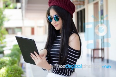 Portrait Of Thai Teen Beautiful Girl Using Her Tablet Stock Photo