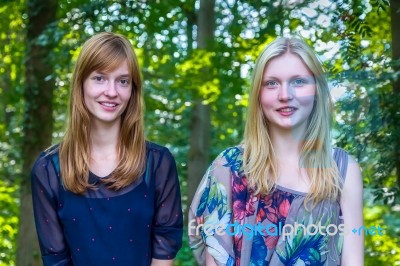 Portrait Of Two Teenage Girls And Trees Background Stock Photo