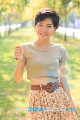 Portrait Of Young And Beautiful Asian Woman Standing In Park Wit… Stock Photo