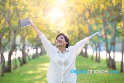 Portrait Of Young Asian Woman And Book In Hand Rising Hand As Vi… Stock Photo