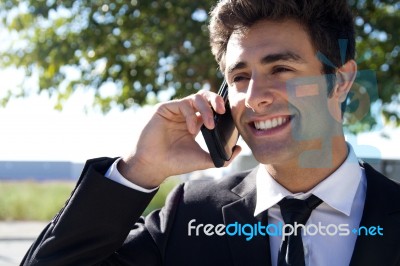 Portrait Of Young Businessman Talking With Smartphone Stock Photo